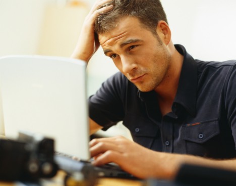 Stressed Young Man Using Laptop