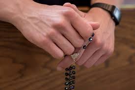 praying hands with rosary